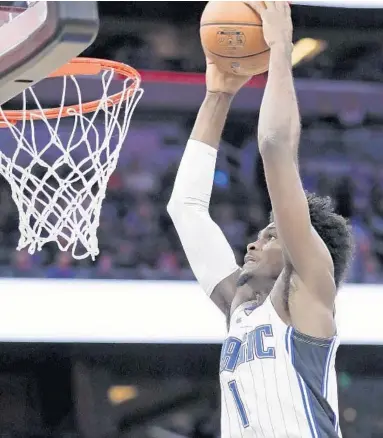  ?? JOHN RAOUX/AP ?? The Magic’s Jonathan Isaac goes up for an unconteste­d dunk against the 76ers on Wednesday night at Amway Center.