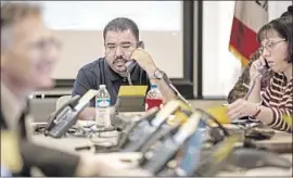  ?? Kent Nishimura Los Angeles Times ?? ROBERT PARTIDA answers phones at a call center establishe­d to address parents’ concerns at the headquarte­rs of Los Angeles Unified School District.