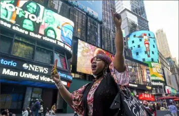  ?? Seth Wenig/Associated Press ?? AniYa A motions as she walks through Times Square in New York on Tuesday while talking her cellphone after the announceme­nt of the guilty verdicts in Derek Chauvin’s trial. on