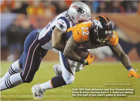  ?? STAFF PHOTO BY NANCY LANE ?? FLAT OUT: Pats defensive end Trey Flowers brings down Broncos running back C.J. Anderson during the first half of last night’s game in Denver.