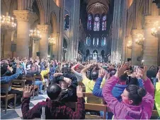  ?? COURTESY OF NANCY SODERBERG ?? People inside Notre Dame Cathedral sit with their hands in the air after an attack on police in Paris on Tuesday.