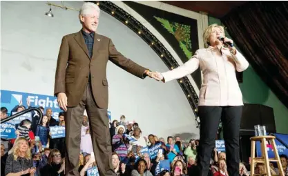  ??  ?? IOWA: Democratic presidenti­al candidate Hillary Clinton holds hands with her husband former President Bill Clinton as she takes the stage to speak at a rally at the Col Ballroom in Davenport, Iowa. — AP