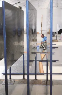  ?? JIM THOMPSON/JOURNAL ?? A worker builds booth dividers for the interior of the new artisan market in Albuquerqu­e’s Sawmill District. The market will host around 70 local artisans once it opens, with both indoor and outdoor space for them to showcase and sell products.