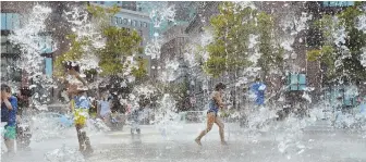  ?? Staff photo by ChRIs ChRIsto ?? SPLISH SPLASH: Children beat yesterday’s heat in the Rings Fountain on the Rose Kennedy Greenway. Highs in the mid- to upper-90s are forecast for today and tomorrow.