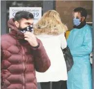  ?? JULIE OLIVER / POSTMEDIA NEWS FILES ?? People waiting outside a COVID-19 testing centre in an
arena in Ottawa recently.