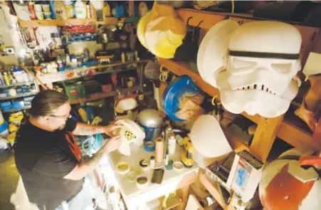  ??  ?? Jeff Rodriquez works on fabricatin­g an X-wing pilot’s helmet before the Dec. 18 premiere of “Star Wars: Episode VII — The Force Awakens.” Rodriquez makes props and costumes in his garage shop in Thornton for Rebel Legion, a “Star Wars” charitable...