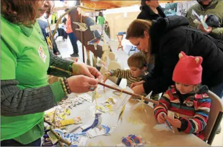  ?? CHARLES PRITCHARD — ONEIDA DAILY DISPATCH ?? Rosalind Skidmore, 3, right, Michelle Lawrence and Ethan Lawrence make their own mobiles featuring local birds on Saturday, Feb. 17, 2018.