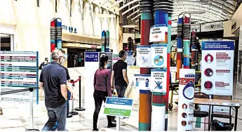  ?? — AFP photo ?? Visitors pass by signs reminding them of sanitary precaution­s they must take as they enter Saint-Louis hospital in Paris.