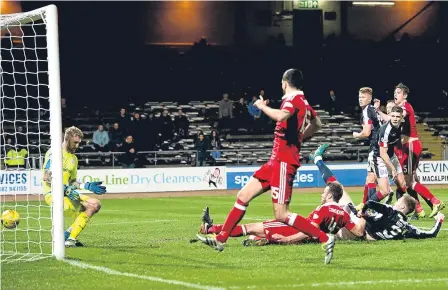 ??  ?? Andy Considine slides in Aberdeen’s seventh goal against Dundee at Dens Park.