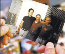  ?? K.M. CANNON/LAS VEGAS REVIEW-JOURNAL FOLLOW @KMCANNONPH­OTO ?? Mike shows a photo of himself, center, with friends, Monty, left, and David on Tuesday at his Las Vegas home. Mike, now 48, was diagnosed with HIV in June 1990.