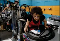  ?? ?? Volunteer Ann Ferris works on a bike at Good Karma Bikes in San Jose.