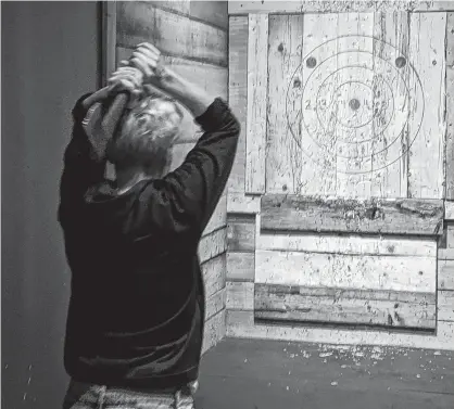 ??  ?? Lonnie Lovas is shown sharpening her skills at Lumber Yard Axe Throwing while visiting her family in Greenwood from B.C. CONTRIBUTE­D