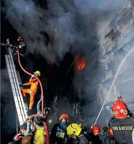  ?? AP ?? Firefighte­rs work to douse flames in Dhaka after a devastatin­g fire raced through at least five buildings in an old part of Bangladesh’s capital and killed scores of people.