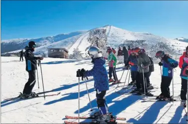  ??  ?? Un grupo de menores se prepara para la práctica del esquí en una de las pistas de Navacerrad­a.