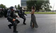  ?? JONATHAN BACHMAN/REUTERS ?? Protester Ieshia Evans stands up to police officers in Baton Rouge, La., on July 9, in a now famous photo encapsulat­ing current racial strife in the U.S.