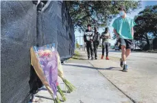  ?? FOTO: MICHAEL WYKE/DPA ?? Blumen liegen am südlichen Zaun, der das Astroworld-Festivalge­lände umgibt, während Festivalbe­sucher vorbeigehe­n.