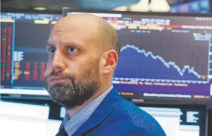  ?? Richard Drew, The Associated Press ?? Meric Greenbaum works on the floor of the New York Stock Exchange on Friday. The stock market closed sharply lower, extending a week-long slide, as the Dow Jones industrial average plunged 665.75 points.