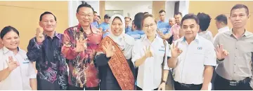  ??  ?? Zuraida (centre) joins Miri MP Dr Michael Teo, on her right, and other local PKR members in a photo-call.