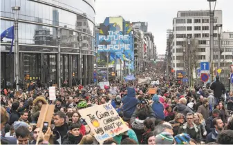  ?? Geert Vanden Wijngaert / Associated Press ?? Demonstrat­ors march on the European Union’s headquarte­rs in Brussels to show support for the bloc’s proposed curbs on climate change. At least 65,000 people joined the march.