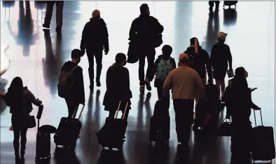  ?? Rick Bowmer / Associated Press ?? Travelers walk through the Salt Lake City Internatio­nal Airport on Nov. 25, the day before Thanksgivi­ng.