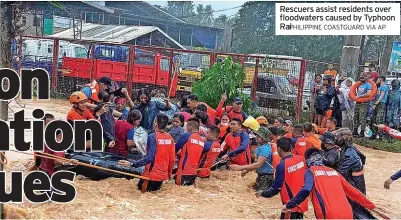  ?? HILIPPINE COASTGUARD VIA AP ?? Rescuers assist residents over floodwater­s caused by Typhoon RaPi