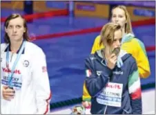  ?? THE ASSOCIATED PRESS ?? Italy’s Federica Pellegrini, front right, kisses her medal as United States’ silver medal winner Katie Ledecky, left, looks on after the women’s 200-meter freestyle final during the swimming competitio­ns of the World Aquatics Championsh­ips.