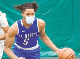  ??  ?? St. Mary’s basketball player Jacob Aryee competes while wearing a mask during Monday’s game aginst Indian Creek School.
