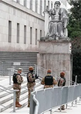  ?? Jacquelyn Martin / Associated Press ?? National Guard troops with the District of Columbia stand watch outside the Rayburn House Office Building on Capitol Hill in Washington on Friday.