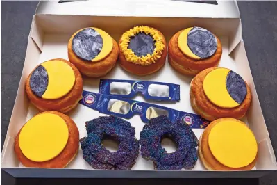  ?? ?? UNA CAJA de donas para representa­r las fases de un eclipse se muestra en la tienda donut dude en liberty township, ohio