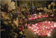  ?? SERGEI GAVRILENKO — THE ASSOCIATED PRESS ?? A woman lights candles by a floral tribute for the victims of Sunday’s fire in a multi-story shopping center in the Siberian city of Kemerovo, about 1,900 miles east of Moscow, Russia, Monday.