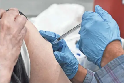  ?? MARK WELSH/DAILY HERALD VIA AP ?? A patient receives the Pfizer COVID-19 vaccinatio­n on Wednesday in Schaumburg, Ill.