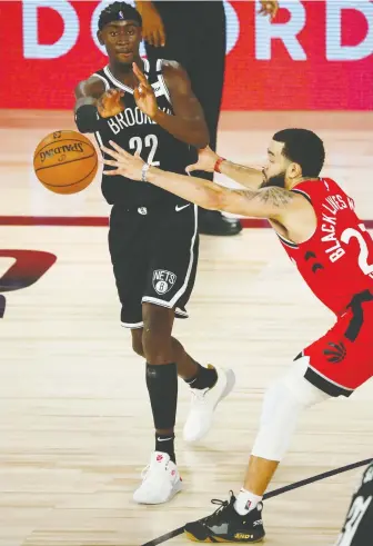  ?? KIM KLEMENT/USA TODAY ?? Nets guard Caris Levert dishes off the ball under pressure from Raptors guard Fred Vanvleet during Game 3 on Friday in Lake Buena Vista, Fla. The Raptors won 117-92 to take a 3-0 series lead.