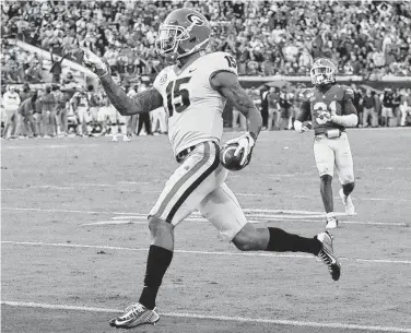  ?? Curtis Compton / TNS ?? Georgia wide receiver Lawrence Cager gets past Florida defensive back Shawn Davis for a 52-yard touchdown reception during the fourth quarter at TIAA Bank Field in Jacksonvil­le, Fla.