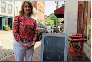  ?? AP/BRIAN WITTE ?? Mary Adams, owner of a bookstore in downtown Annapolis, Md., stands Saturday by a sign outside her store. Adams knew two of the journalist­s who were killed in Thursday’s attack on the Capital Gazette.