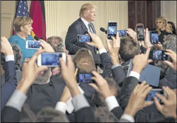  ?? STEPHEN CROWLEY / THE NEW YORK TIMES ?? President Donald Trump and Chancellor Angela Merkel of Germany hold a news conference at the White House on Friday. Regarding being wiretapped by British spies, Trump says he was repeating a Fox News assertion.