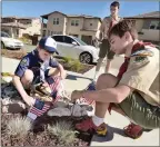  ?? Dan Watson/The Signal ?? (Above) Cub Scout Zander Sears, 8, left, plants a flag Saturday in the yard of one of 60 homes on Juniper Springs Drive in Canyon Country with the help of his Boy Scout brothers Zachary, 15, center, and Skyler, 12, in honor of the Fourth of July. (Below) Zander prepares to plant a flag in the yard of another Canyon Country home.