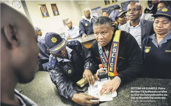  ?? Picture: Jacques Nelles ?? SETTING AN EXAMPLE. Police Minister Fikile Mbalula certifies an ID at the Sunnyside police station on Mandela Day yesterday.