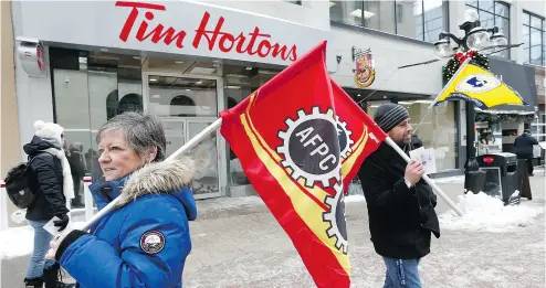  ?? TONY CALDWELL / POSTMEDIA NEWS ?? Union workers and supporters demonstrat­e in front of Tim Hortons in Ottawa Wednesday. An escalating public battle between franchisee­s and the company goes against Tim Hortons wholesome image, a marketing professor says.