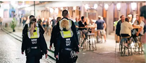  ?? FOTO: DPA ?? Polizisten im Dienst patrouilli­eren nach Mitternach­t in der Altstadt zwischen Feiernden.