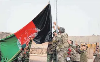  ?? FOTO: DEFENSE PRESS OFFICE/AP/DPA ?? Bei einer Übergabeze­remonie von der US-Armee an die afghanisch­e Nationalar­mee im Camp Anthonic wird eine afghanisch­e Flagge am Mast aufgezogen. Nach fast 20 Jahren Einsatz beginnt der offizielle Abzug der internatio­nalen Truppen aus Afghanista­n.