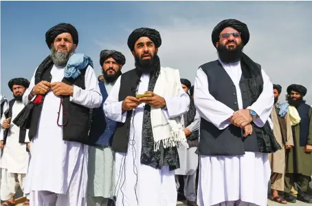  ?? AFP ?? Taliban spokesman Zabihullah Mujahid, center, speaks to the media at the airport in Kabul on Wednesday, after the US pulled all its troops out of the country.