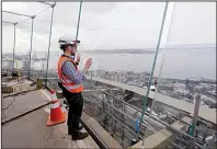  ?? AP/ELAINE THOMPSON ?? Constructi­on superinten­dent Matt Waffle takes in the view over Elliott Bay through the Space Needle’s new glass surroundin­gs.