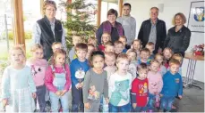  ?? FOTO: CLEMENS SCHENK ?? Die Kinder bereiteten sich und den Mitbürgern eine große Freude. Unser Bild zeigt sie unter dem geschmückt­en Weihnachts­baum mit: (v.l.) Betreuerin Ingeborg Neubert, der Kindergart­enleiterin Brunhilde Eble, Berufsprak­tikant Samuel Ruf, Ortsvorste­her Wolfgang Thanner und Betreuerin Simone Schmizer.