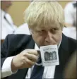  ?? JON SUPER — THE ASSOCIATED PRESS ?? Britain’s Prime Minister Boris Johnson takes a drink from a prison mug as he talks with prison staff during a visit to Leeds prison, Northern England, Tuesday.