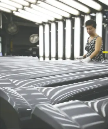  ?? COLE BURSTON / BLOOMBERG FILES ?? Employees on the floor at auto parts manufactur­er Magna Polycon Industries’ facility
in Guelph, Ont. Magna says it can handle the whole vehicle developmen­t process.