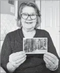  ?? KATIE SMITH/THE GUARDIAN ?? Carol Maclauchla­n sits in her Charlottet­own home while admiring a postcard she sent to her parents 49 years ago that was recently returned to her.