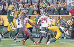  ?? WM. GLASHEEN/USA TODAY NETWORK-WISCONSIN. ?? Packers running back Aaron Jones dives into the end zone for the game-winning touchdown in overtime.