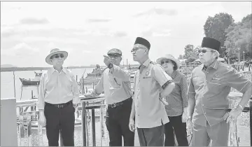  ??  ?? Wan Junaidi (left) being briefed on a project in Telaga Air.