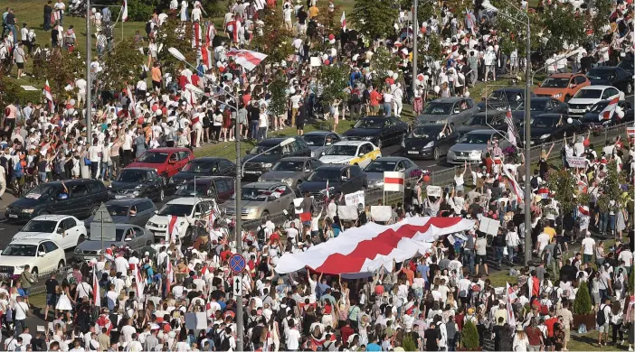 ?? FOTO: SERGEI GAPON/LEHTIKUVA/AFP ?? Belarusier demonstrer­ade mot landets president Aleksandr Lukasjenko i Minsk på söndagen i vad som uppges vara den största demonstrat­ionen i landets historia. Demonstran­terna bär den historiska
■ röd-vita flaggan.