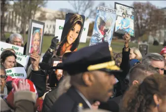  ?? Brendan Smialowski / AFP / Getty Images ?? Opponents of the measure to let gun owners carry concealed firearms across state lines protest outside the U.S. Capitol. The House passed the bill on a mostly party-line 231-198 vote.